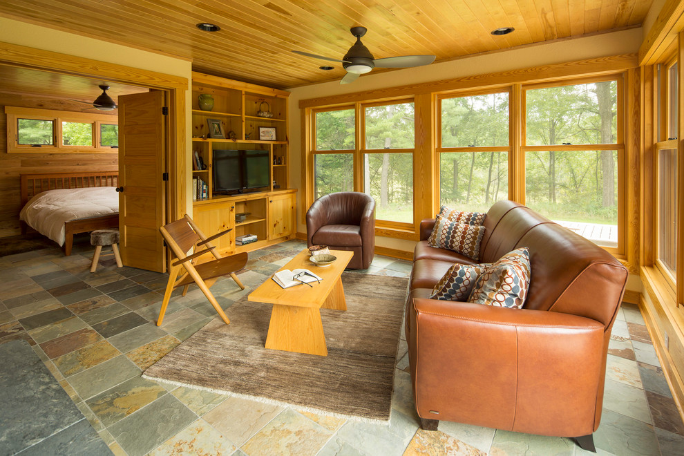 Immagine di un soggiorno stile rurale con pareti gialle e TV autoportante
