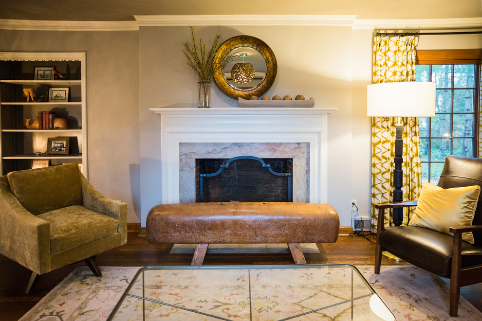 Immagine di un soggiorno minimalista con pareti grigie, pavimento in legno massello medio, camino classico e cornice del camino in pietra
