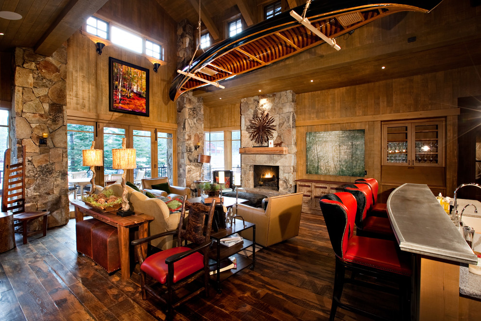 This is an example of a rustic living room in San Francisco with a standard fireplace and a stone fireplace surround.