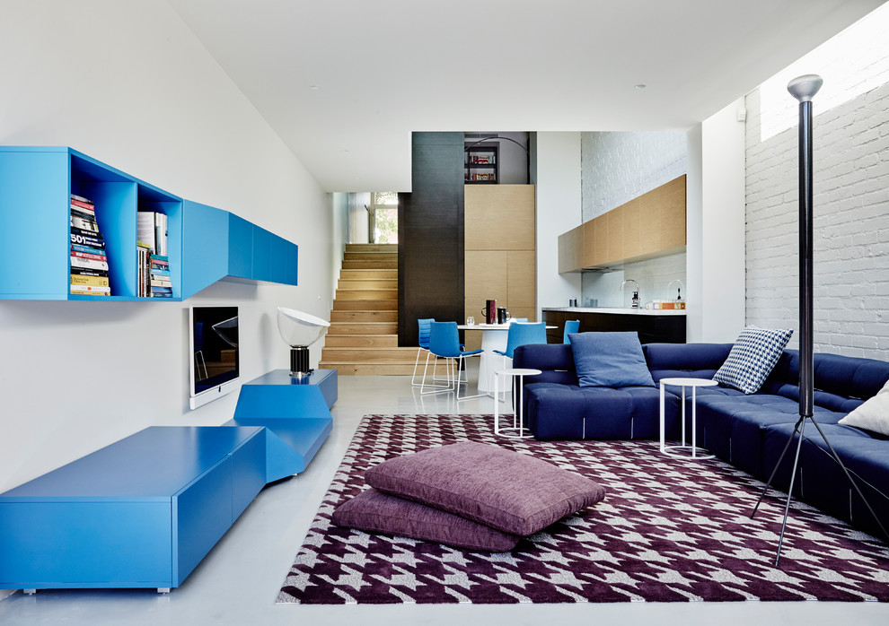 Стильный дизайн: открытая гостиная комната в современном стиле с белыми стенами, телевизором на стене и белым полом - последний тренд