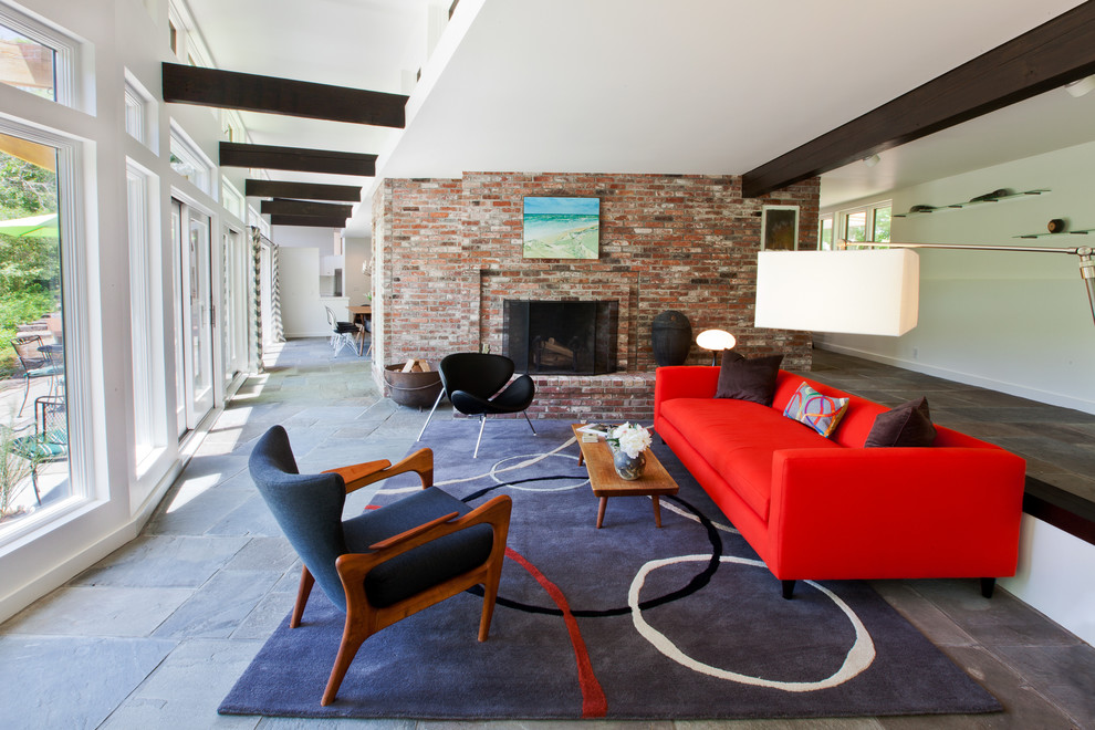 Photo of a large contemporary formal open plan living room in Boston with white walls, slate flooring, a standard fireplace, a brick fireplace surround, no tv and grey floors.