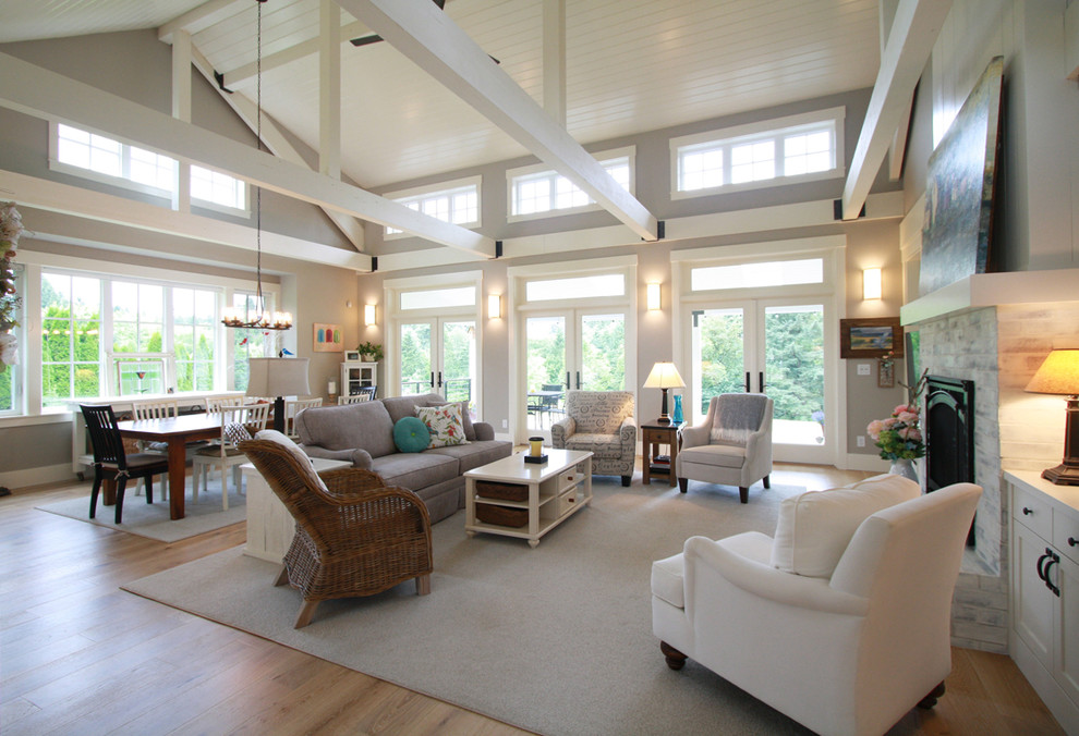 Offenes, Großes Landhaus Wohnzimmer mit beiger Wandfarbe, hellem Holzboden, Kamin, gefliester Kaminumrandung und braunem Boden in Portland
