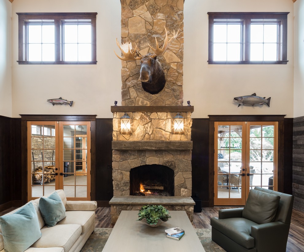 Photo of a large rustic formal enclosed living room in Portland with multi-coloured walls, dark hardwood flooring, a standard fireplace, a stone fireplace surround and brown floors.