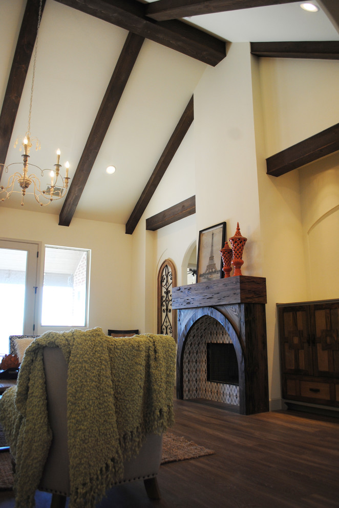 Cette photo montre un grand salon éclectique ouvert avec un mur beige, un sol en vinyl, une cheminée standard, un manteau de cheminée en bois et un téléviseur encastré.