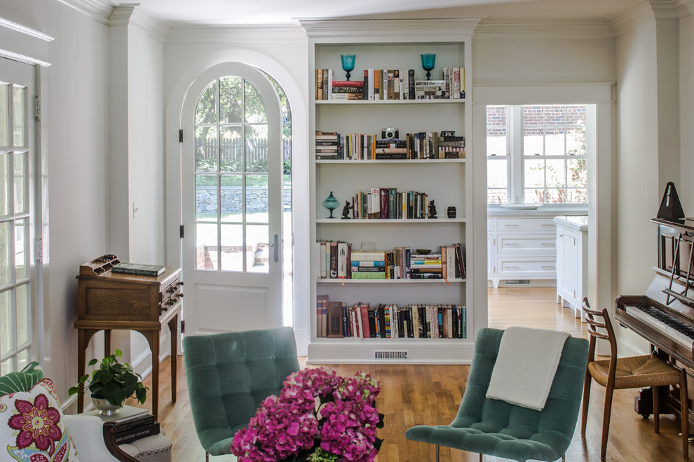 Diseño de biblioteca en casa abierta tradicional de tamaño medio sin chimenea y televisor con paredes beige, suelo de madera en tonos medios y suelo beige