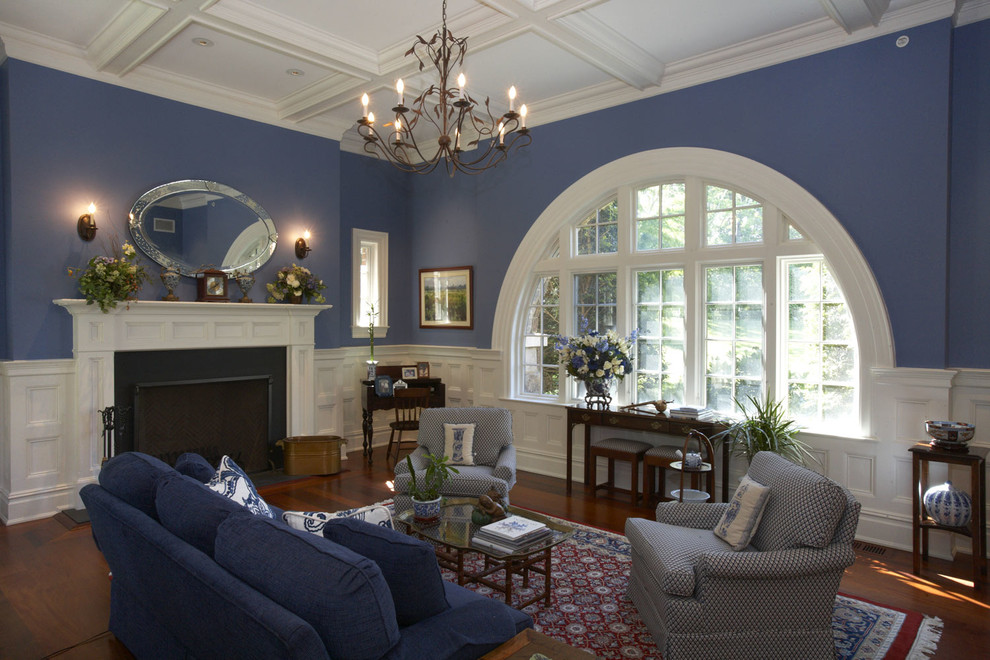 Idéer för att renovera ett vintage vardagsrum, med blå väggar, mörkt trägolv, en standard öppen spis och en spiselkrans i trä