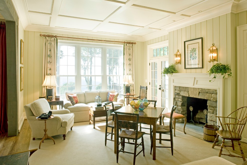 Пример оригинального дизайна: открытая гостиная комната в классическом стиле с бежевыми стенами, ковровым покрытием, печью-буржуйкой и фасадом камина из камня
