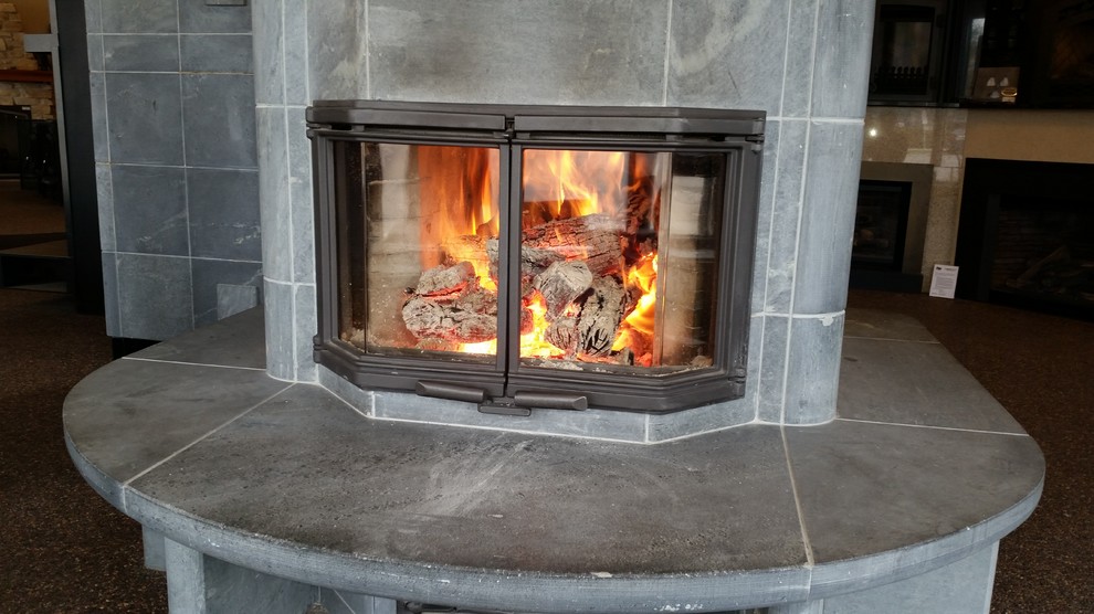 ミネアポリスにある高級な広い北欧スタイルのおしゃれな独立型リビング (両方向型暖炉、石材の暖炉まわり) の写真