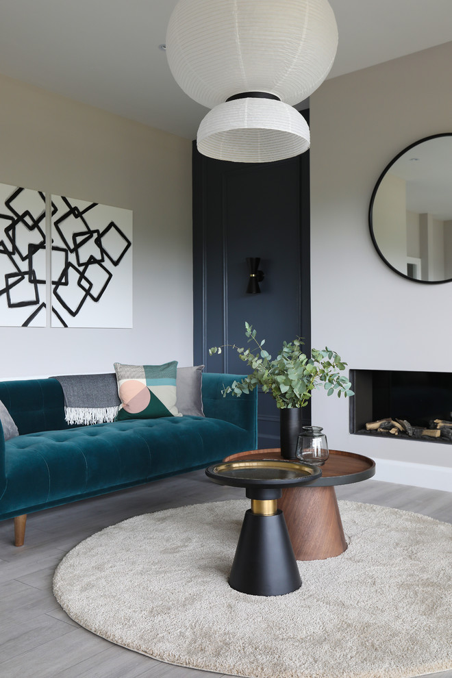 This is an example of a contemporary open plan living room in Dublin with grey walls, laminate floors, a hanging fireplace and no tv.