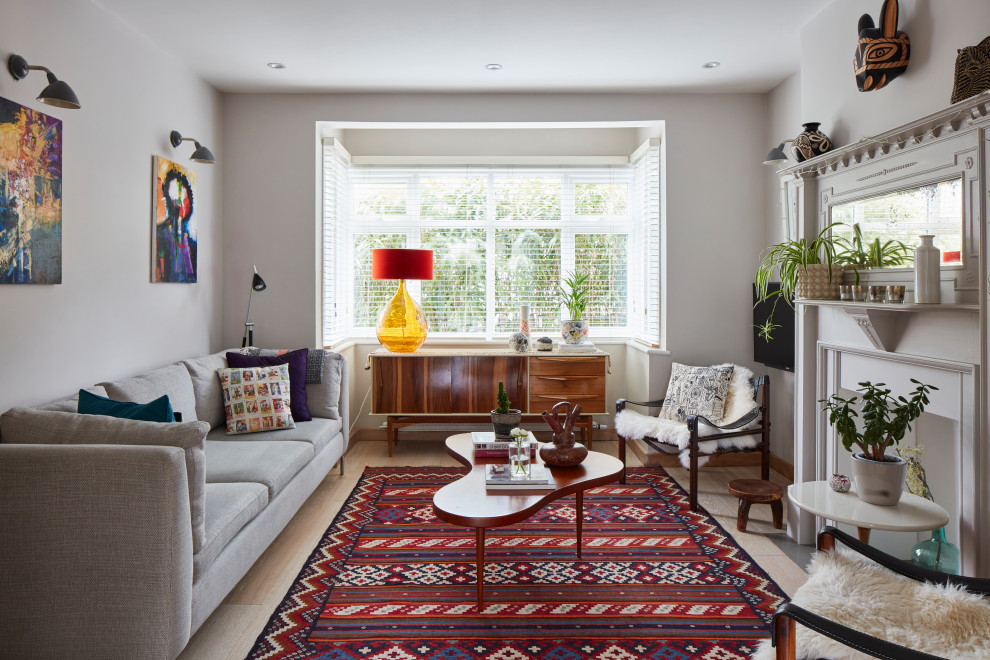Abgetrenntes Mediterranes Wohnzimmer mit weißer Wandfarbe, Kamin, TV-Wand und beigem Boden in London
