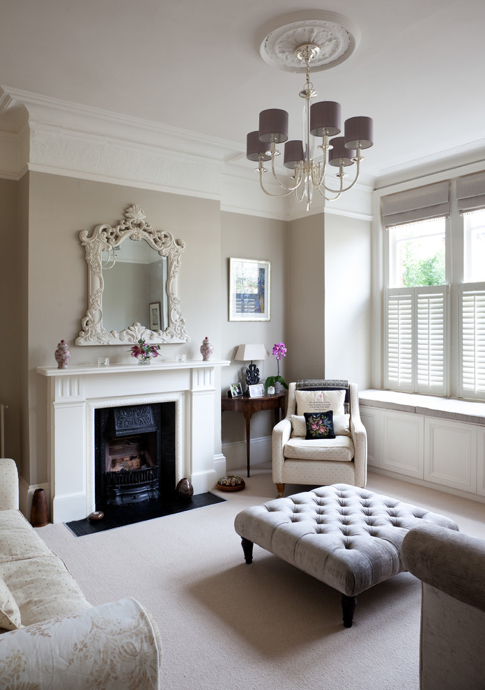 Victorian formal and grey and cream enclosed living room in London with grey walls, carpet, a standard fireplace and no tv.