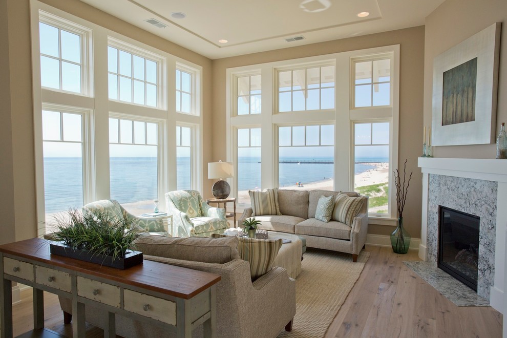 Large beach style open concept light wood floor living room photo in Grand Rapids with beige walls, a standard fireplace and a stone fireplace