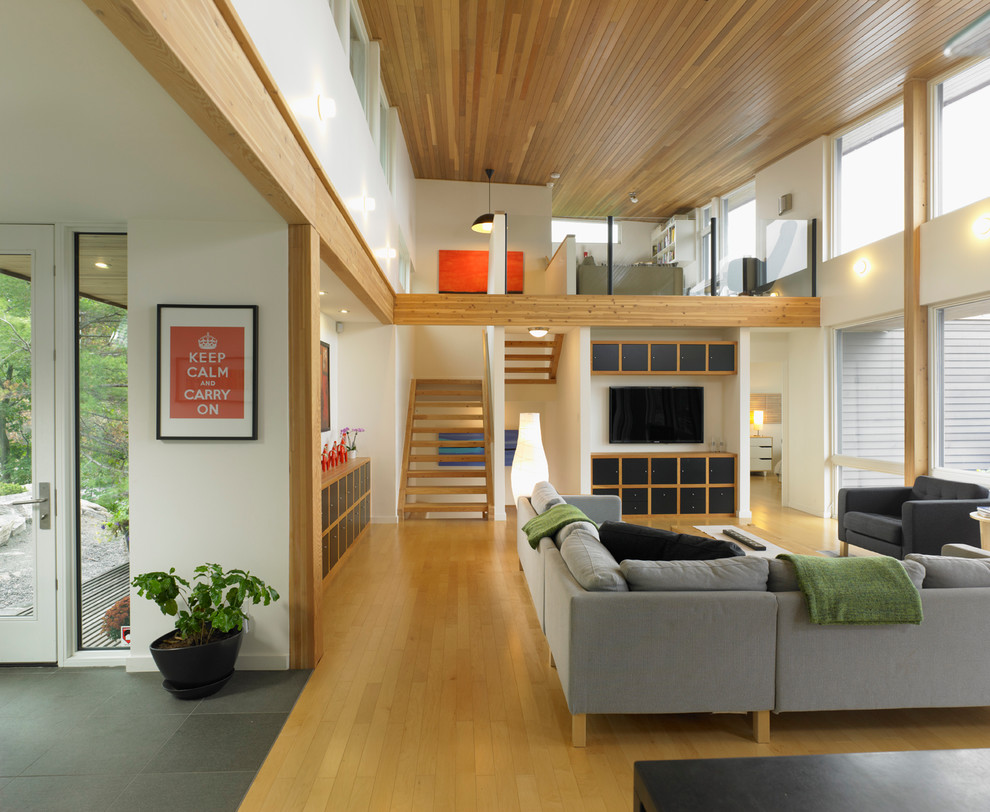 Modernes Wohnzimmer mit braunem Holzboden und TV-Wand in Seattle