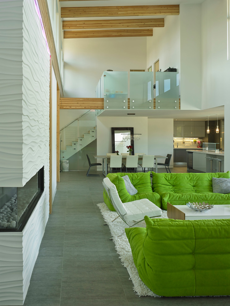 Стильный дизайн: двухуровневая гостиная комната в стиле модернизм с белыми стенами, полом из керамогранита, угловым камином и фасадом камина из плитки без телевизора - последний тренд