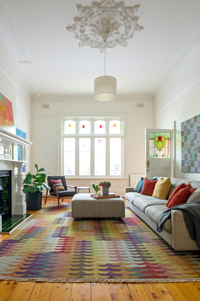 Immagine di un soggiorno design chiuso con sala formale, pareti bianche, pavimento in legno massello medio e camino classico