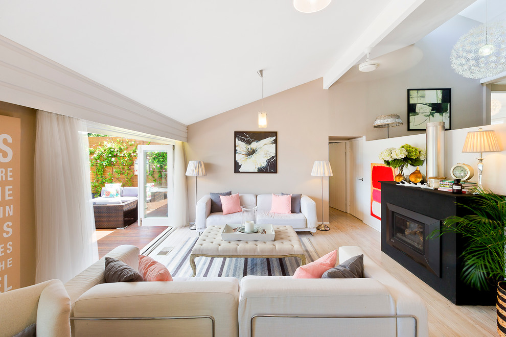 Großes Modernes Wohnzimmer mit beiger Wandfarbe, hellem Holzboden, Gaskamin und Kaminumrandung aus Metall in Sydney