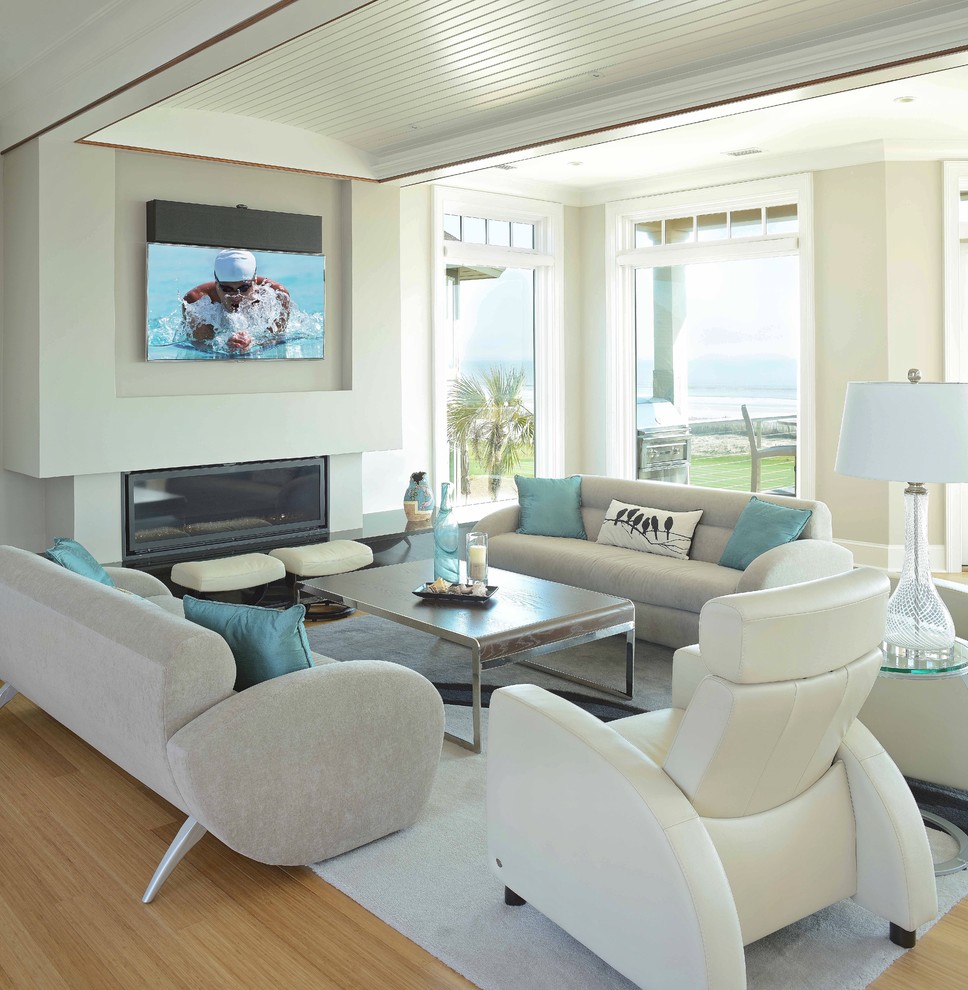 Идея дизайна: большая открытая гостиная комната в стиле модернизм с серыми стенами, полом из бамбука, стандартным камином, фасадом камина из камня и телевизором на стене