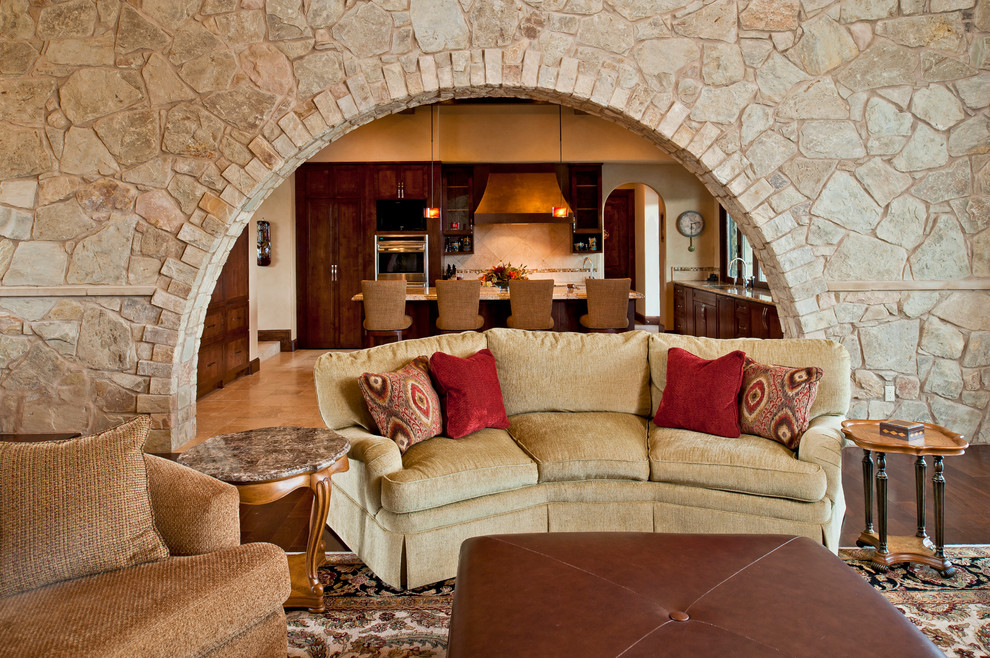 Mediterranean open plan living room in Austin with beige walls and dark hardwood flooring.