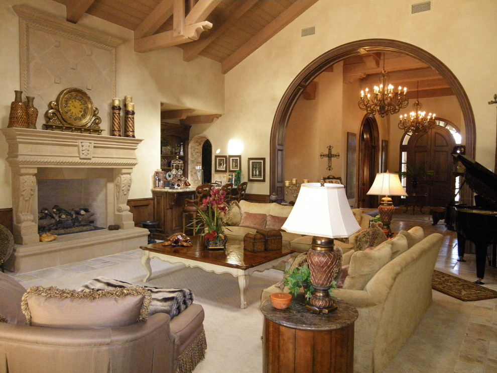 Inspiration for an expansive mediterranean open plan living room in San Diego with beige walls, travertine flooring, a standard fireplace, a stone fireplace surround, a built-in media unit and beige floors.