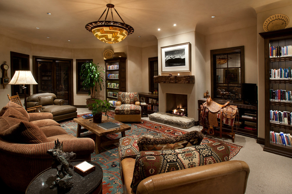 Inspiration for a large mediterranean enclosed carpeted living room library remodel in Phoenix with beige walls, a standard fireplace, a plaster fireplace and a tv stand