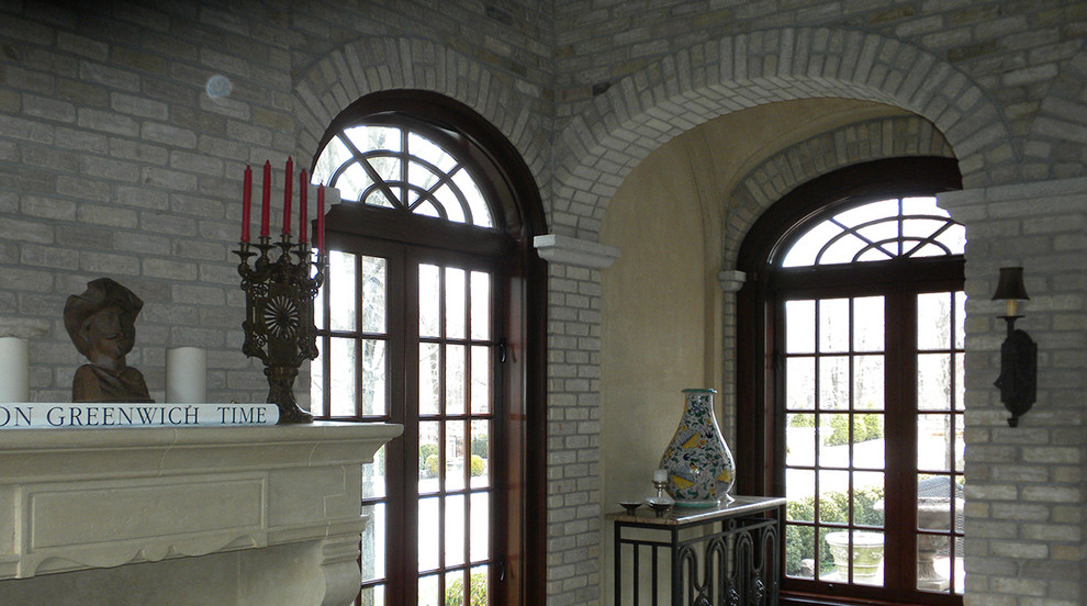 Стильный дизайн: парадная, открытая гостиная комната среднего размера в средиземноморском стиле с серыми стенами, стандартным камином и фасадом камина из камня без телевизора - последний тренд