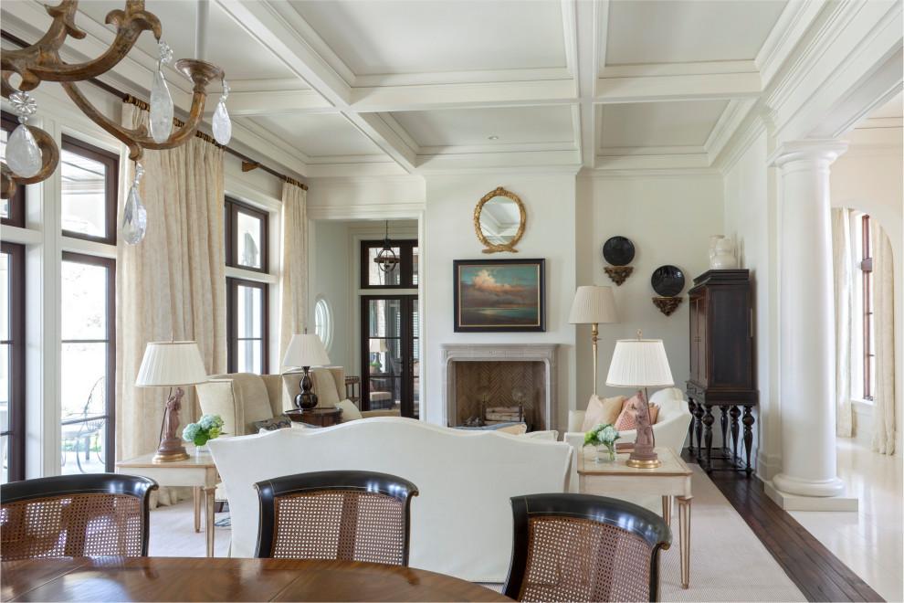 Стильный дизайн: парадная гостиная комната в средиземноморском стиле с белыми стенами, темным паркетным полом, стандартным камином, фасадом камина из штукатурки и коричневым полом - последний тренд