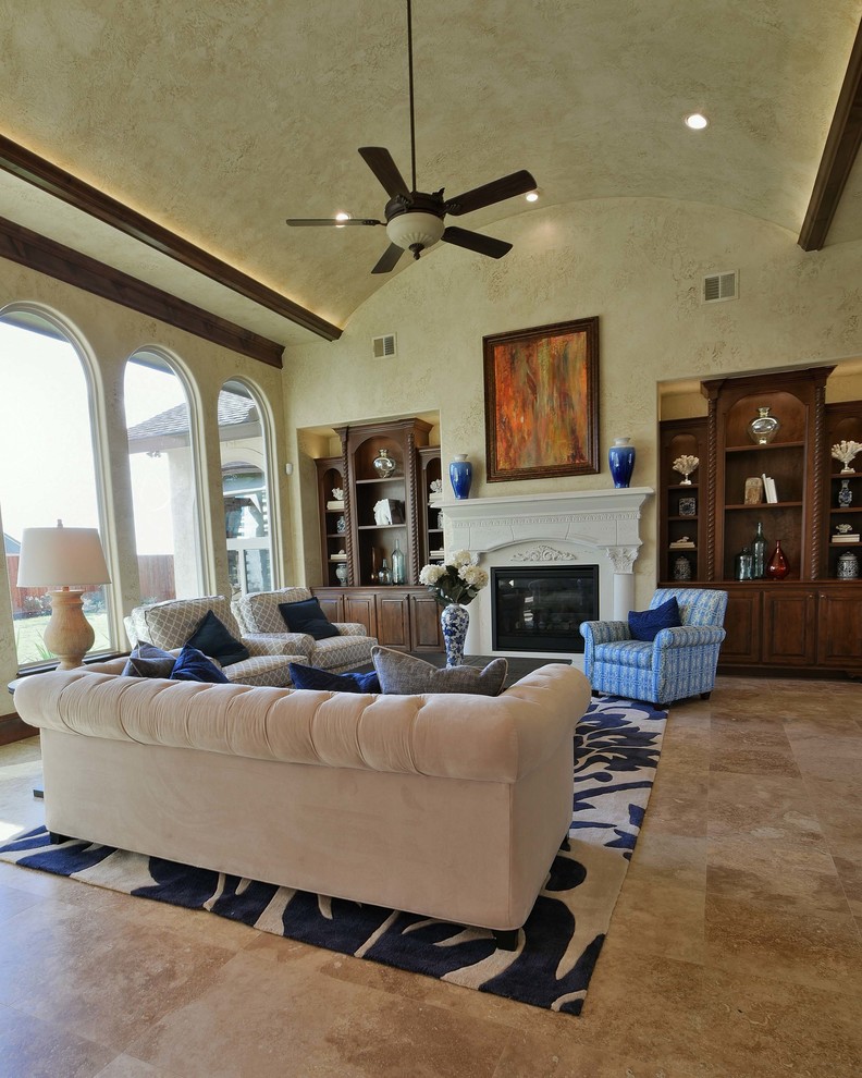 Large mediterranean open plan living room in Houston with beige walls, travertine flooring, a standard fireplace, a stone fireplace surround, no tv and beige floors.