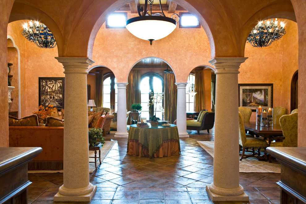 На фото: огромная гостиная комната в средиземноморском стиле с оранжевыми стенами