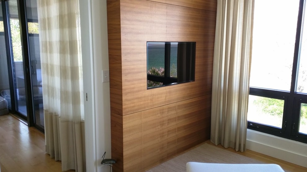 Immagine di un grande soggiorno design chiuso con pareti marroni, parquet chiaro, TV a parete e pavimento marrone