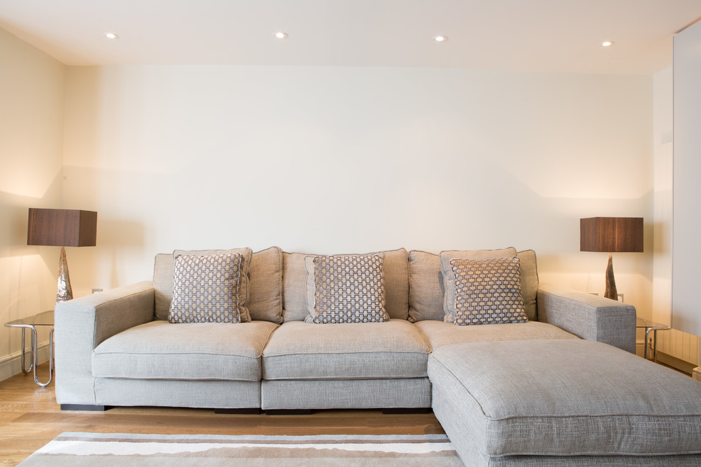 Idée de décoration pour un salon tradition avec un mur blanc et un sol en bois brun.