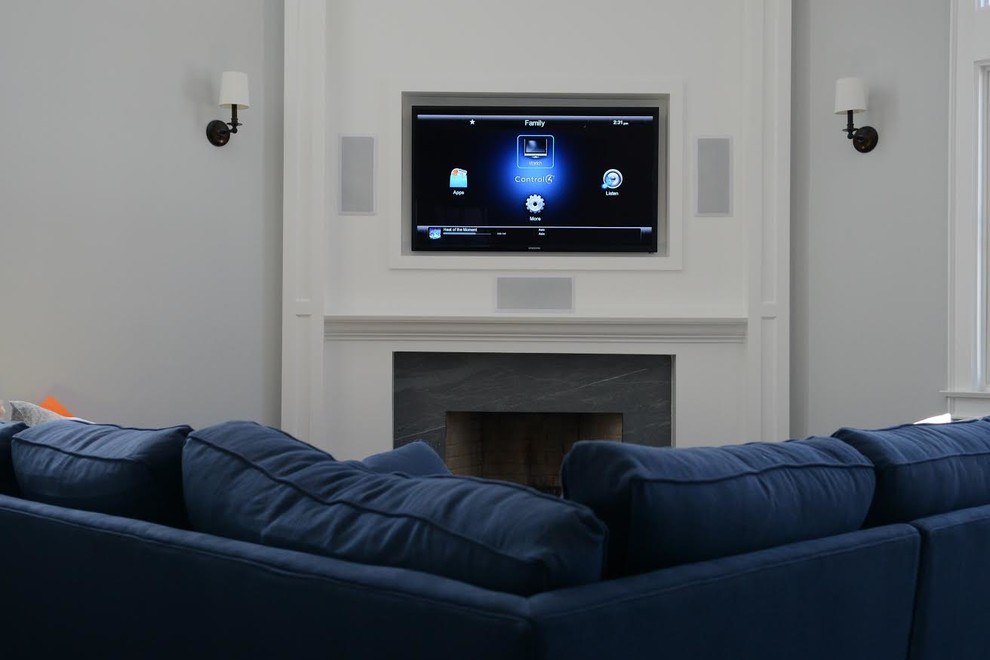 Aménagement d'un salon classique avec un téléviseur encastré, un mur gris, une cheminée standard et un manteau de cheminée en pierre.