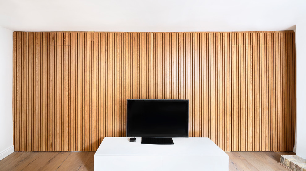 Foto de salón abierto escandinavo de tamaño medio con paredes blancas, suelo de madera clara, estufa de leña, televisor independiente y suelo multicolor