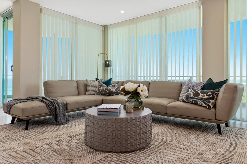 На фото: открытая гостиная комната в морском стиле с белыми стенами, ковровым покрытием и телевизором на стене