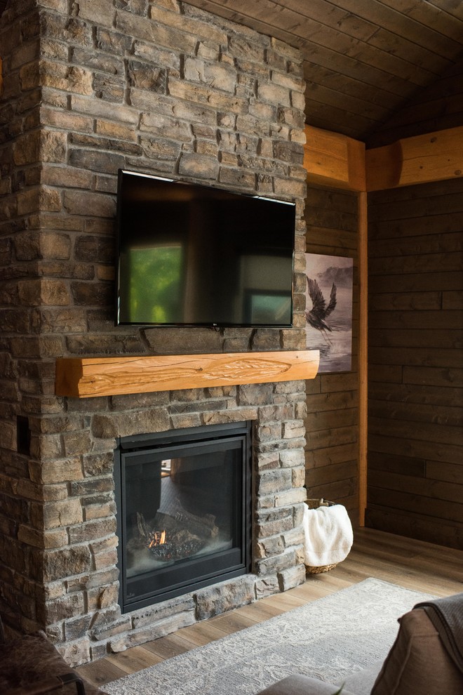 バンクーバーにある小さなラスティックスタイルのおしゃれなリビング (茶色い壁、リノリウムの床、標準型暖炉、レンガの暖炉まわり、壁掛け型テレビ、茶色い床) の写真