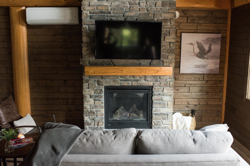 This is an example of a small rustic formal open plan living room in Vancouver with brown walls, lino flooring, a standard fireplace, a brick fireplace surround, a wall mounted tv and brown floors.