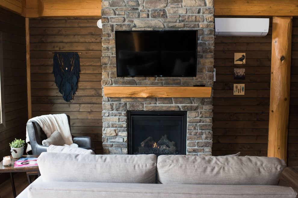 バンクーバーにある小さなラスティックスタイルのおしゃれなリビング (茶色い壁、ラミネートの床、標準型暖炉、レンガの暖炉まわり、壁掛け型テレビ、茶色い床) の写真