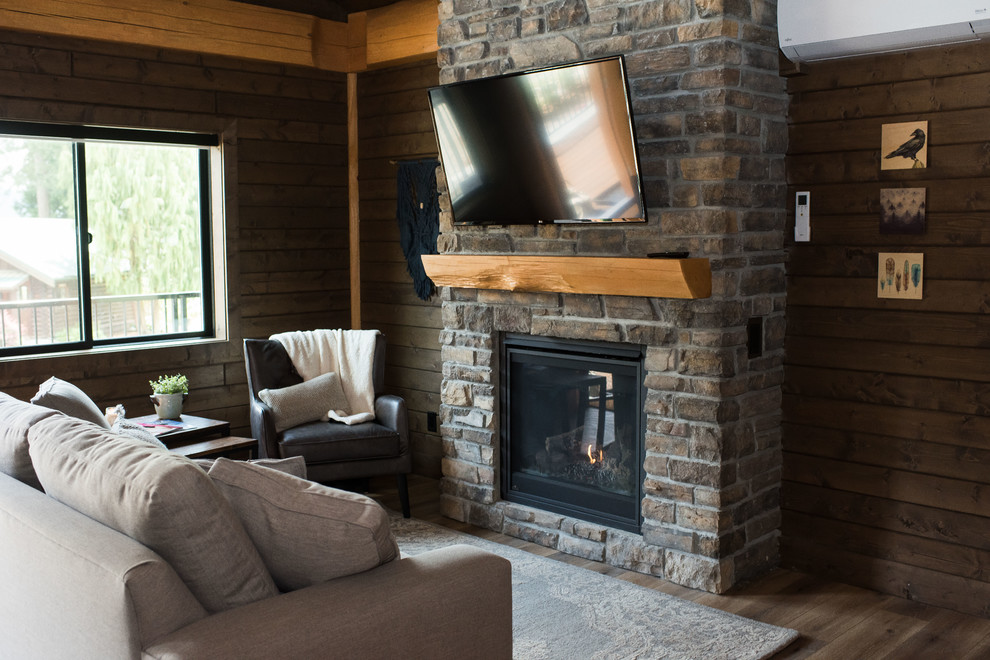 Small mountain style formal and open concept laminate floor and brown floor living room photo in Vancouver with brown walls, a standard fireplace, a brick fireplace and a wall-mounted tv