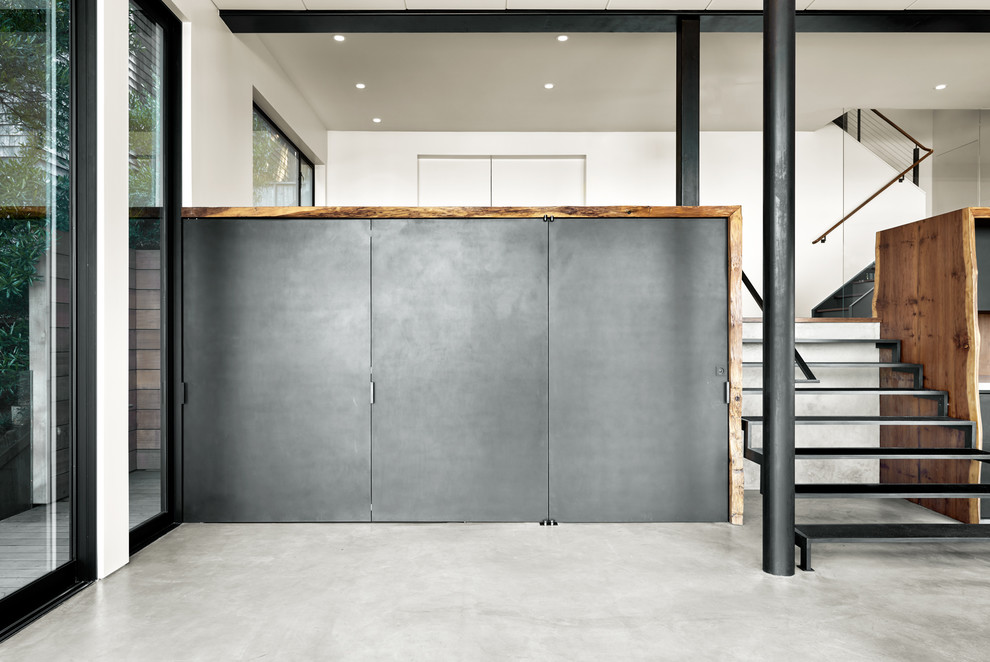 Esempio di un soggiorno minimalista di medie dimensioni e stile loft con angolo bar, pareti nere, pavimento in cemento, nessuna TV e pavimento grigio