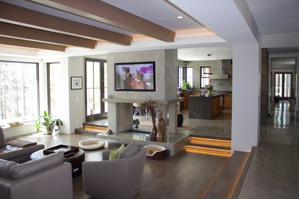 Свежая идея для дизайна: открытая гостиная комната среднего размера в современном стиле с серыми стенами, светлым паркетным полом, двусторонним камином, фасадом камина из штукатурки и телевизором на стене - отличное фото интерьера