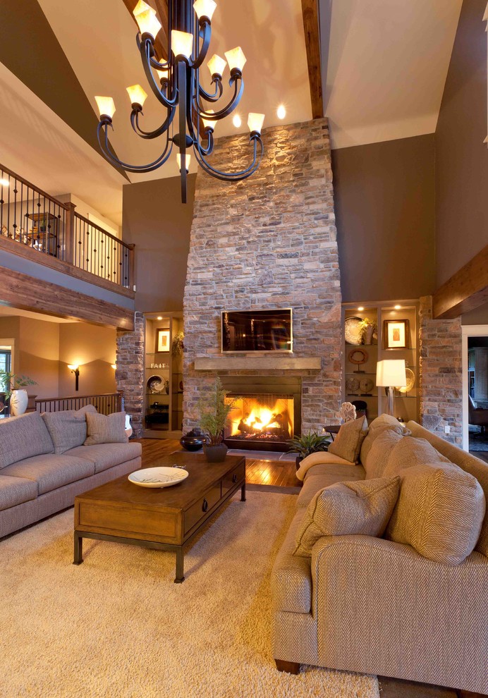Large cottage enclosed carpeted and beige floor living room photo in Other with brown walls, a standard fireplace, a stone fireplace and a wall-mounted tv