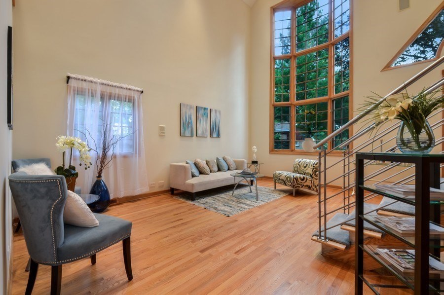 Cette photo montre un salon mansardé ou avec mezzanine moderne de taille moyenne avec un mur blanc, un sol en bois brun et un sol marron.