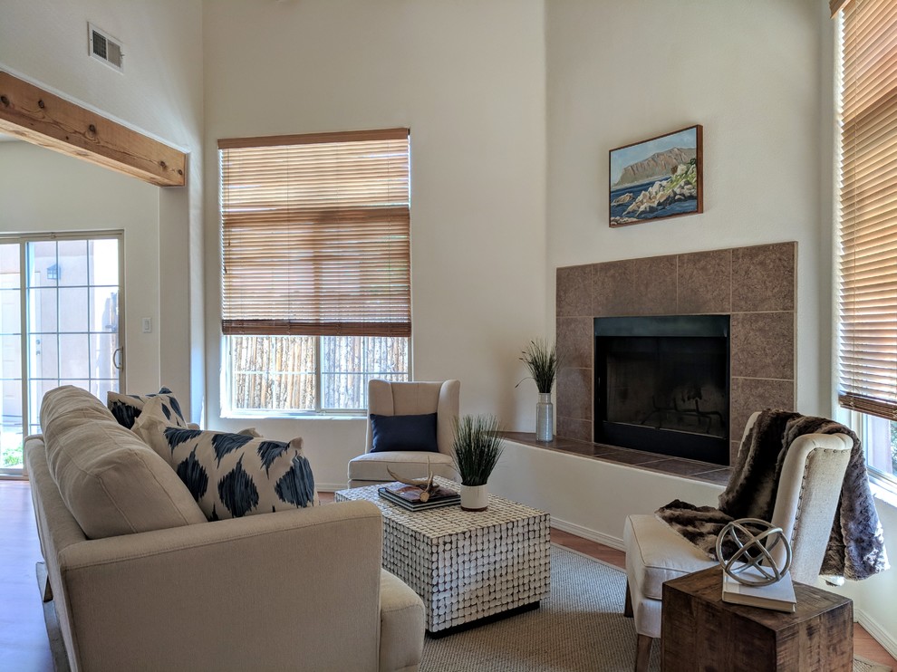 Kleines, Fernseherloses Mediterranes Wohnzimmer im Loft-Stil mit weißer Wandfarbe, braunem Holzboden, Eckkamin, gefliester Kaminumrandung und braunem Boden in Sonstige