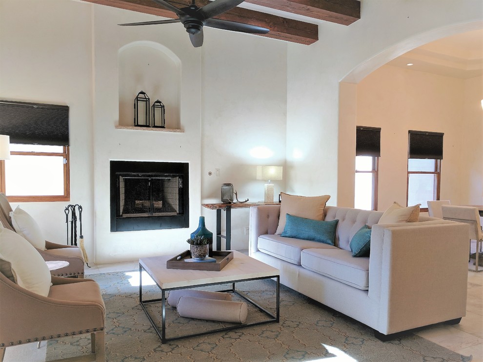 Inspiration for a mid-sized southwestern open concept travertine floor and multicolored floor living room remodel in Other with white walls, a standard fireplace, a plaster fireplace and no tv