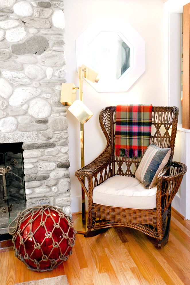 Immagine di un soggiorno stile marinaro con libreria e cornice del camino in pietra