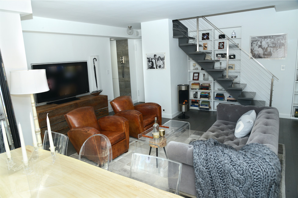 Cette photo montre un salon tendance de taille moyenne avec un mur blanc, un sol en bois brun, un téléviseur indépendant et un sol gris.