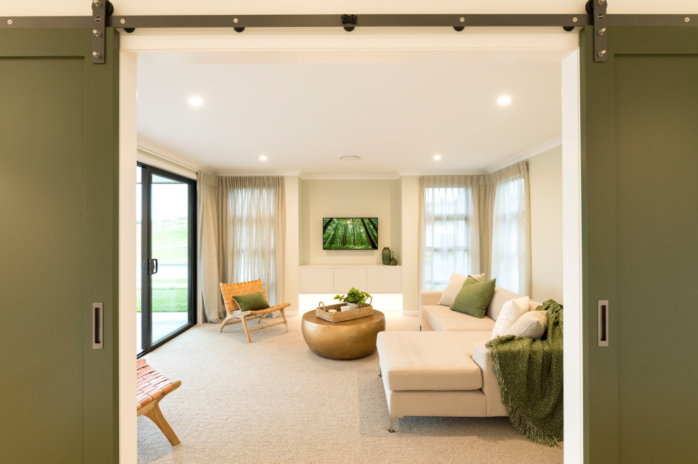 Immagine di un grande soggiorno design chiuso con sala formale, pareti verdi, moquette, TV a parete e pavimento beige