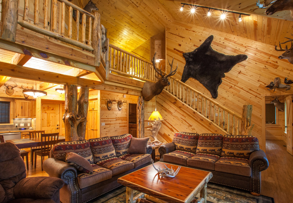 Foto de salón para visitas abierto rústico de tamaño medio sin chimenea y televisor con suelo de madera en tonos medios y suelo marrón