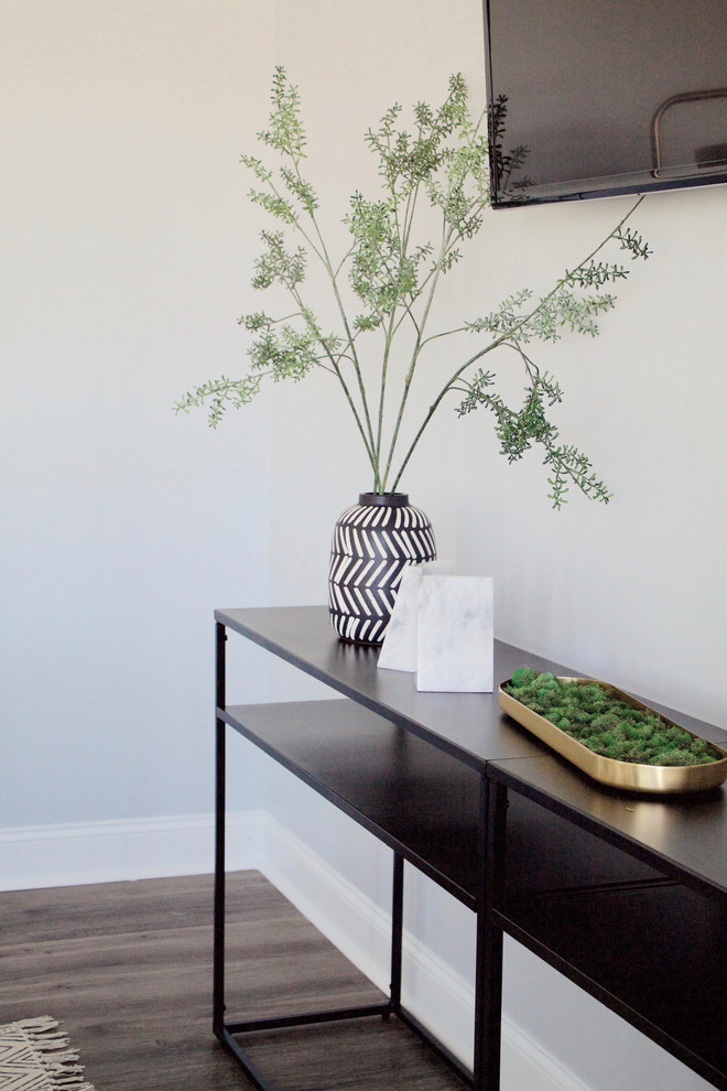 Modelo de salón abierto minimalista de tamaño medio sin chimenea con paredes grises, suelo vinílico, televisor colgado en la pared y suelo gris