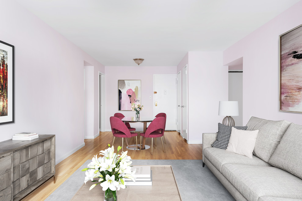 На фото: открытая гостиная комната среднего размера в стиле неоклассика (современная классика) с розовыми стенами, паркетным полом среднего тона и коричневым полом без камина с
