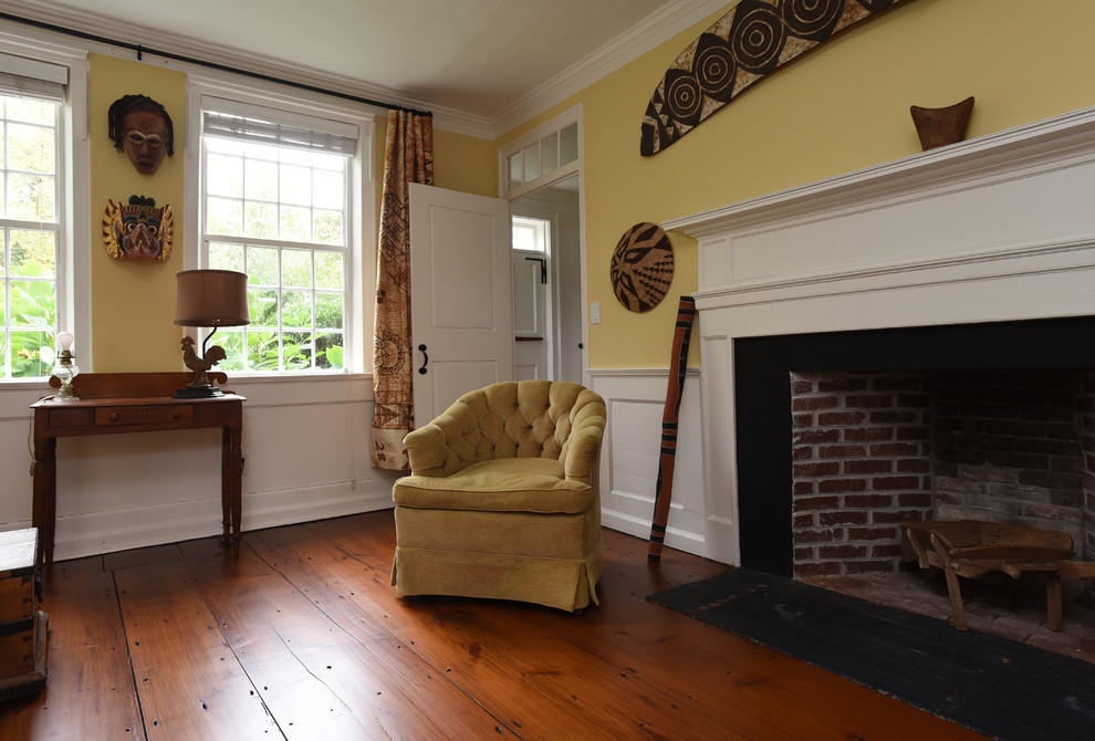 ボストンにある高級な中くらいなカントリー風のおしゃれなリビング (黄色い壁、濃色無垢フローリング、標準型暖炉、木材の暖炉まわり、テレビなし、茶色い床) の写真